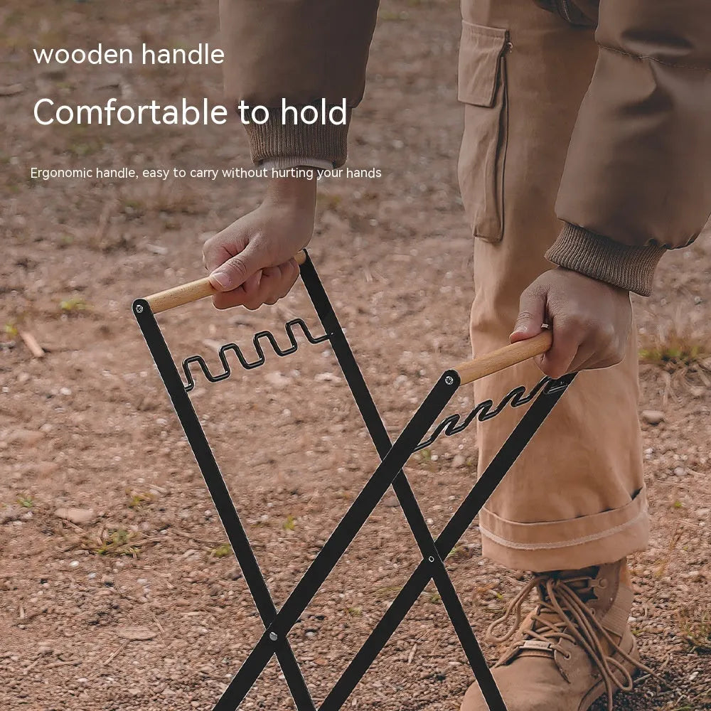 Black iron folding trash storage rack with a wooden handle for hanging bin bags.
