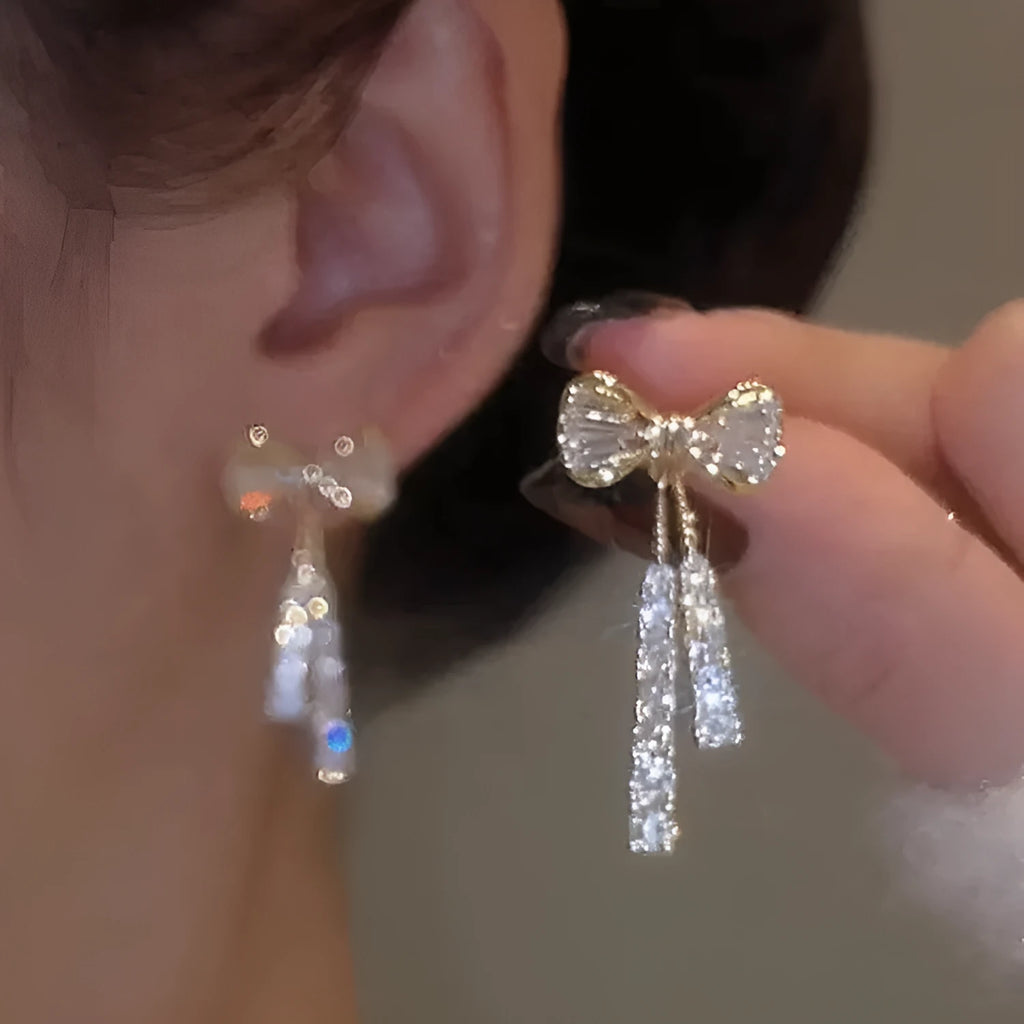 Gold butterfly earrings with rhinestones and bow element on alloy base