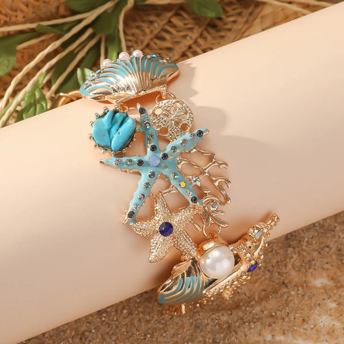 Alloy rhinestone bracelet with boat anchor and starfish design in turquoise, coral red, or coral blue.