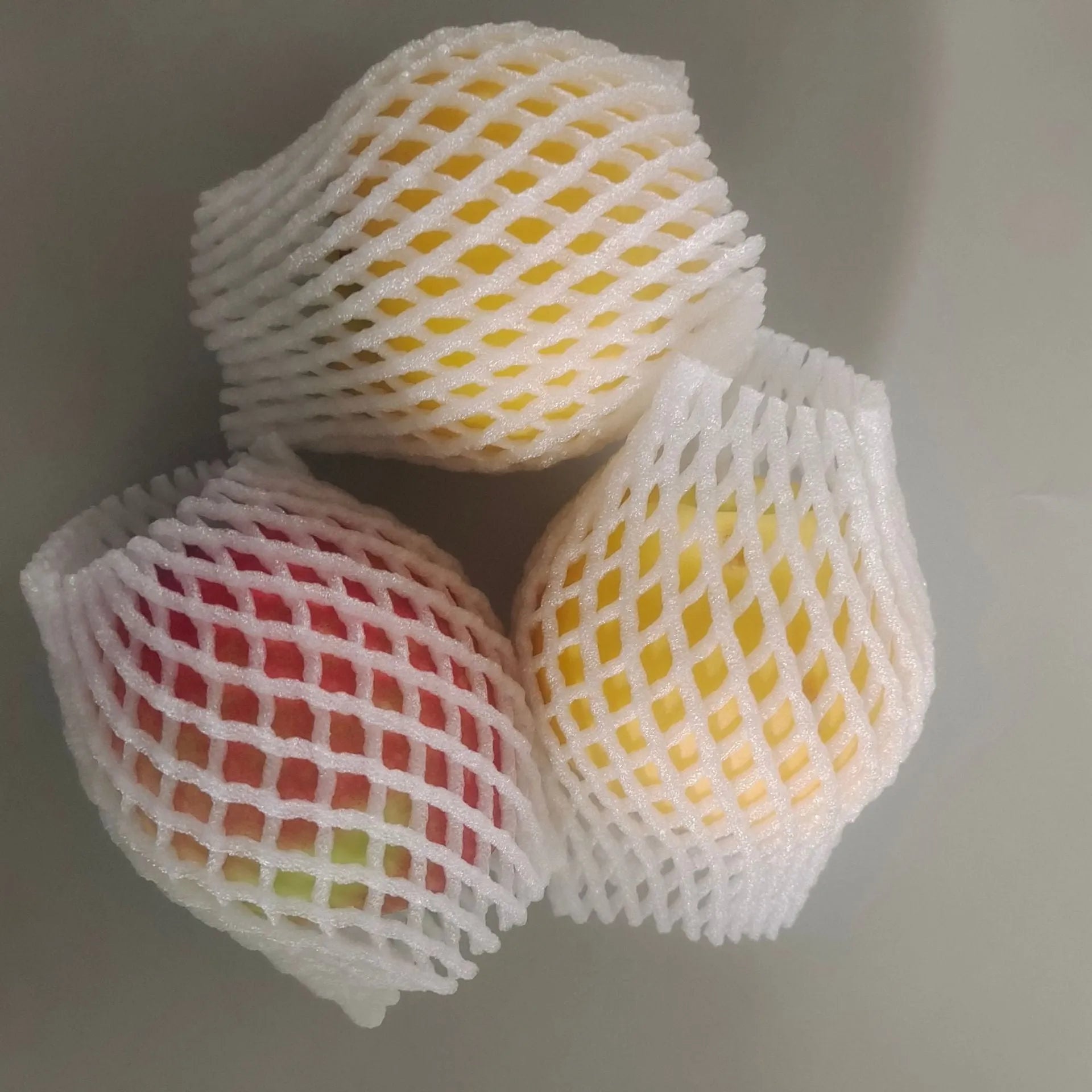 White foam protective net cover for apples, pears, peaches and oranges.