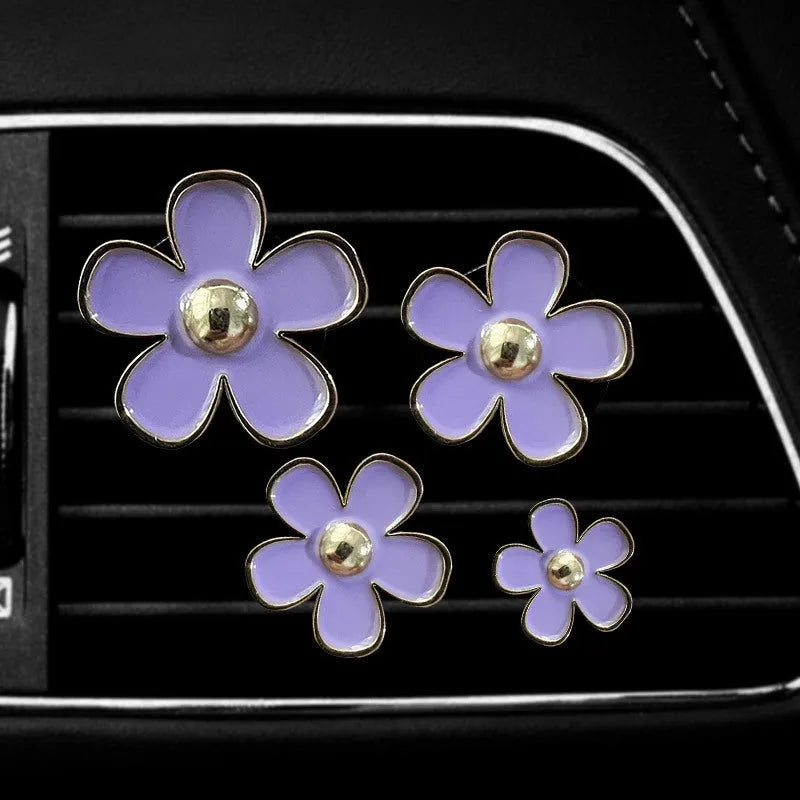 Set of four metal flower-shaped car vent aromatherapy clips in assorted colours
