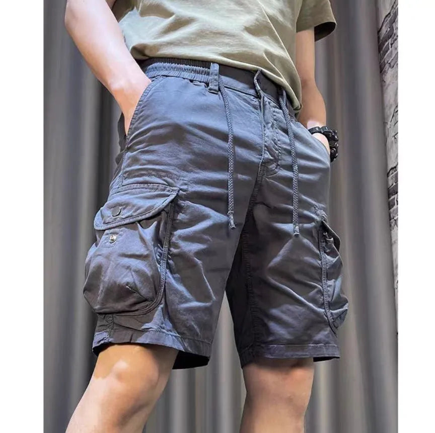 Loose straight-leg multi-pocket casual overalls trousers in khaki colour on a hanger.