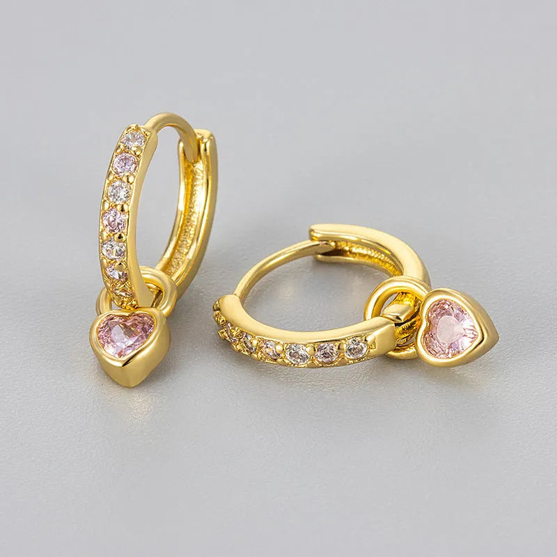 Gold colour heart-shaped clip earring with a central blue zircon stone on a white background.