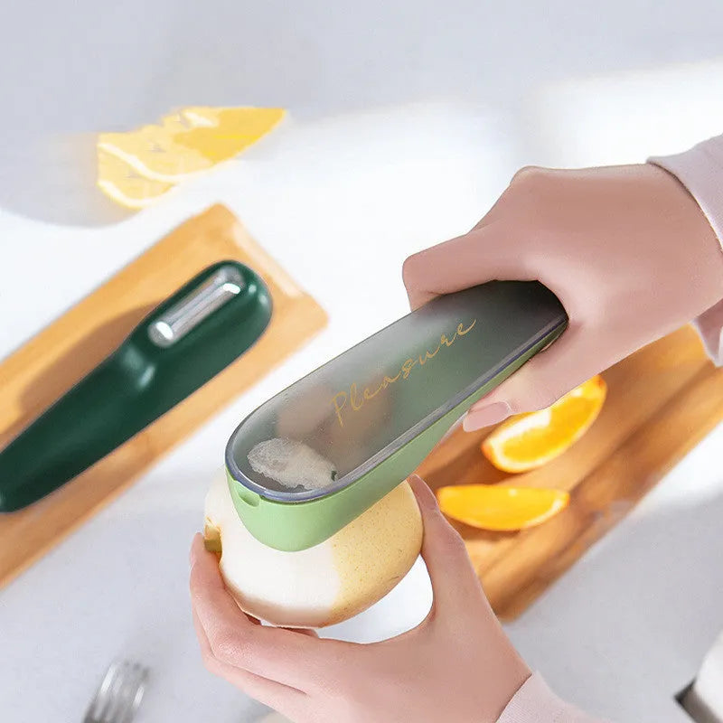 Dark green kitchen peeler with storage tube showing stainless steel blade and hanging hole on handle