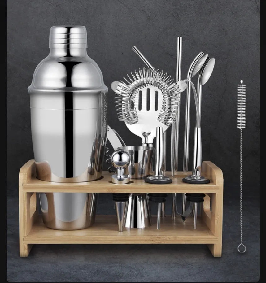 23-piece stainless steel cocktail set with shaker, jiggers, strainer and bar tools on a countertop.