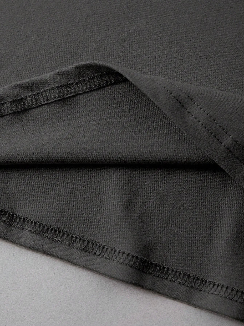 Loose short-sleeve cotton T-shirt on a hanger, showing round neckline, available in black, green, grey, and orange.