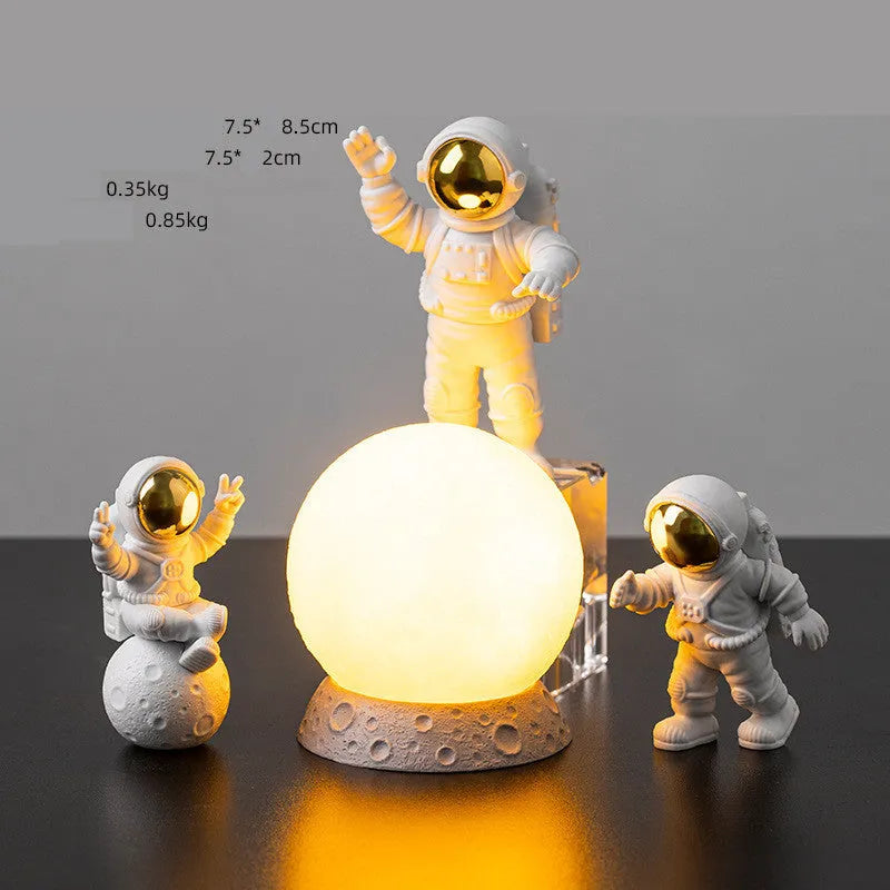 Three resin astronaut figurines for car dashboard decoration, gold finish, placed on dashboard