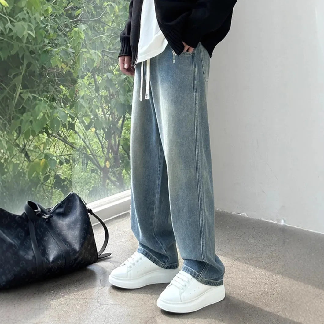 Men's loose fit straight-leg jeans in black or blue with drawstring waist closure