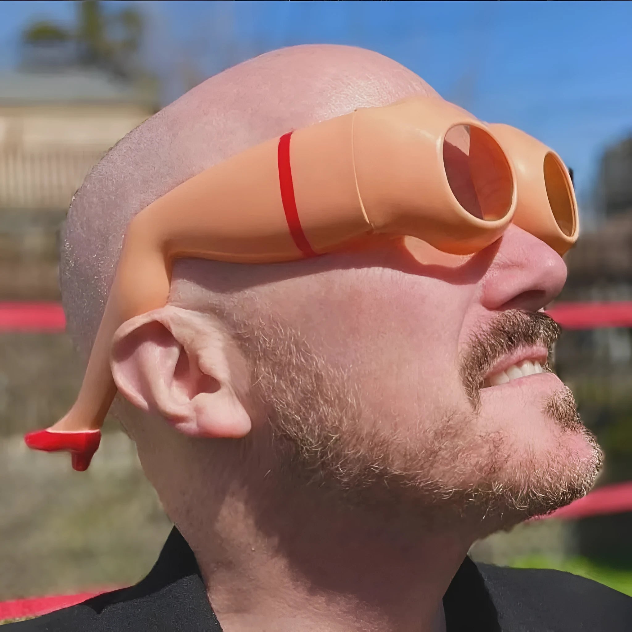 Orange plastic novelty sunglasses with leg hip style arms and a large wide frame.