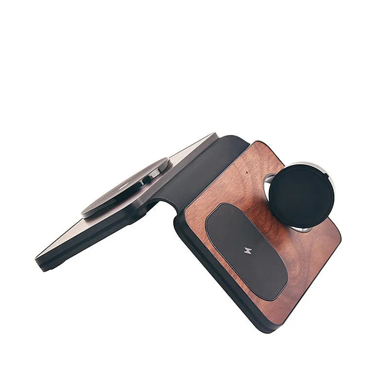 Three-in-one foldable magnetic wireless charger with walnut base and stand, charging a phone, earbuds and watch.