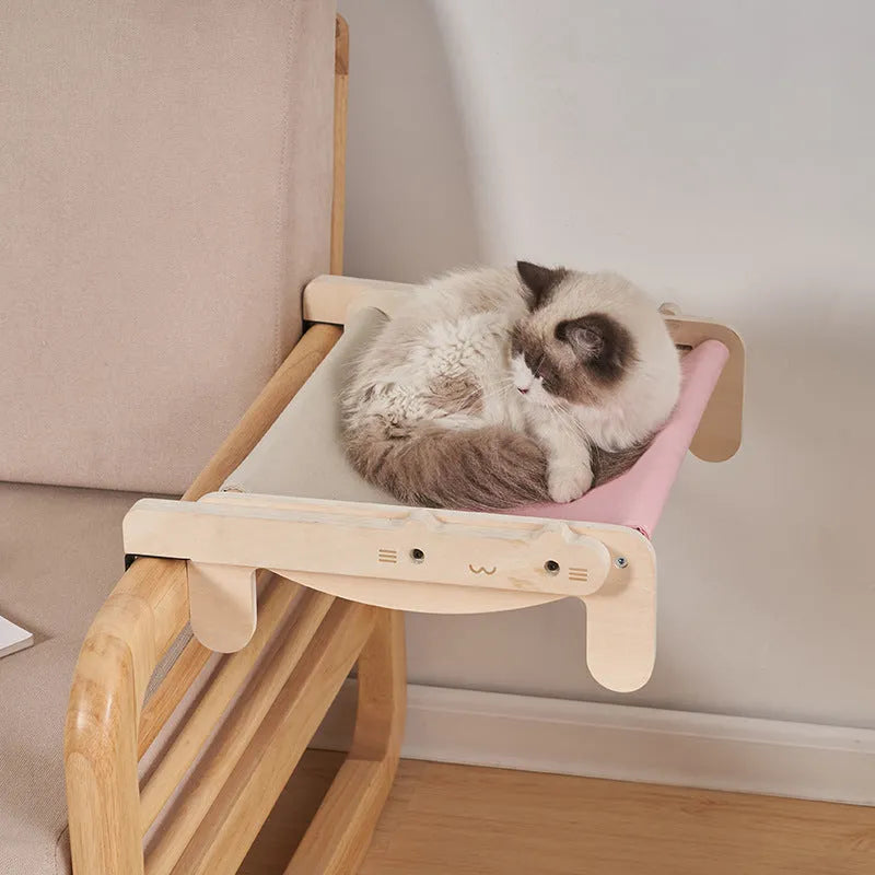 Solid wood cat bed with a removable plaid cushion on a wooden frame.