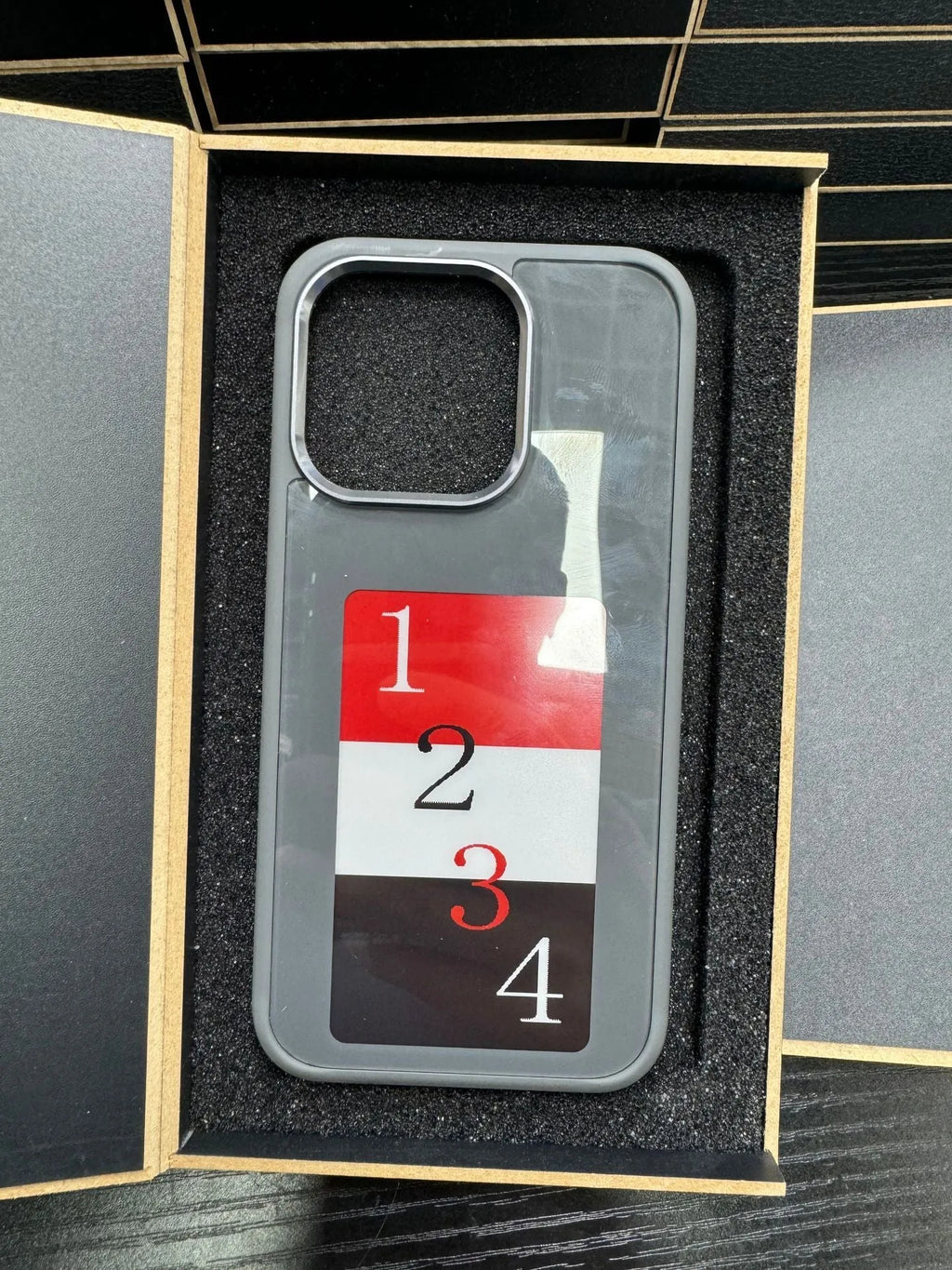 E-ink phone case for Apple iPhone with NFC screen projection displayed in black TPU, showing a custom image on the e-ink screen