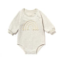 Long-sleeved waffle cotton baby romper in a neutral colour on a hanger, showing the triangular climbing front closure.