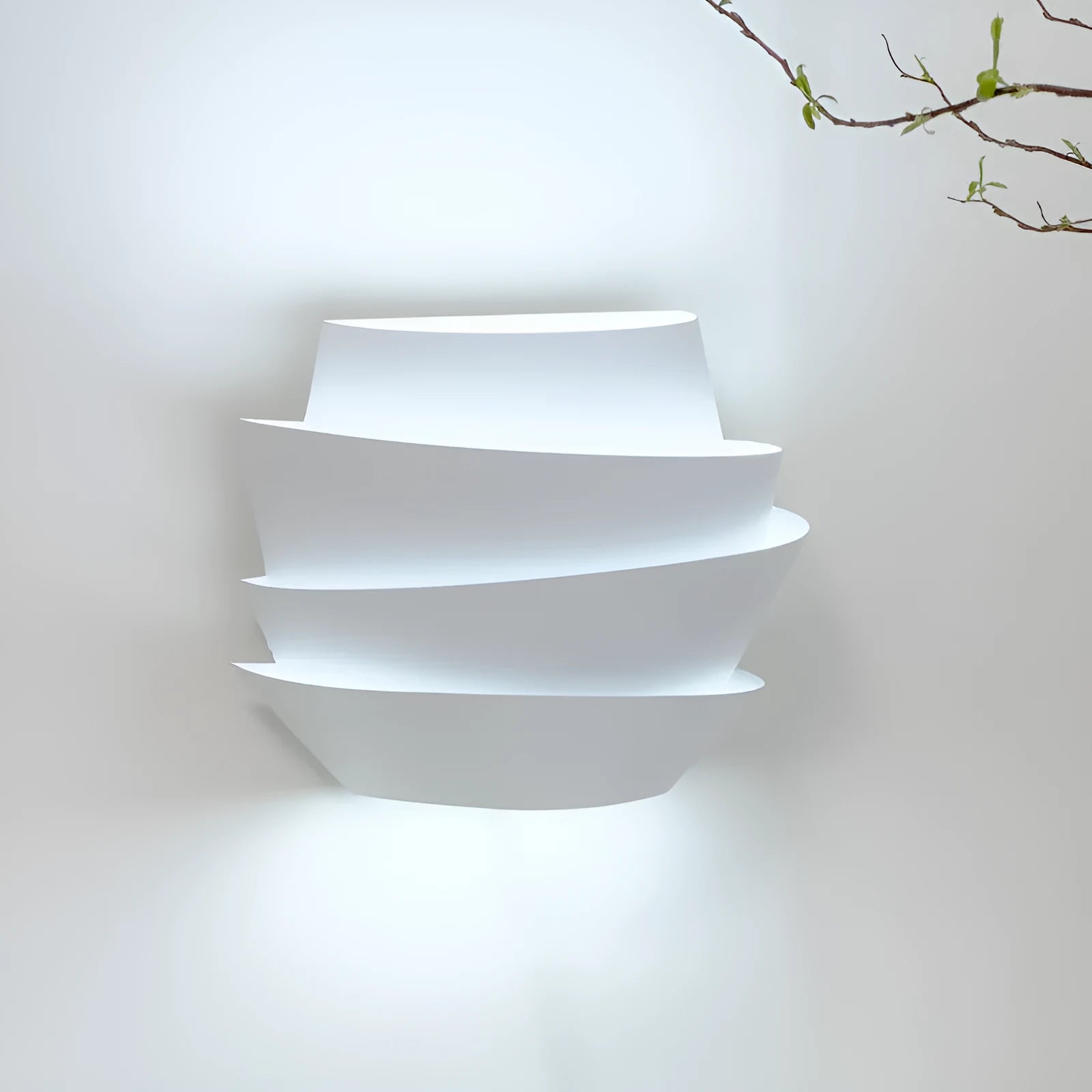 Modern white wall lamp with pine cone decoration mounted on a plain wall.