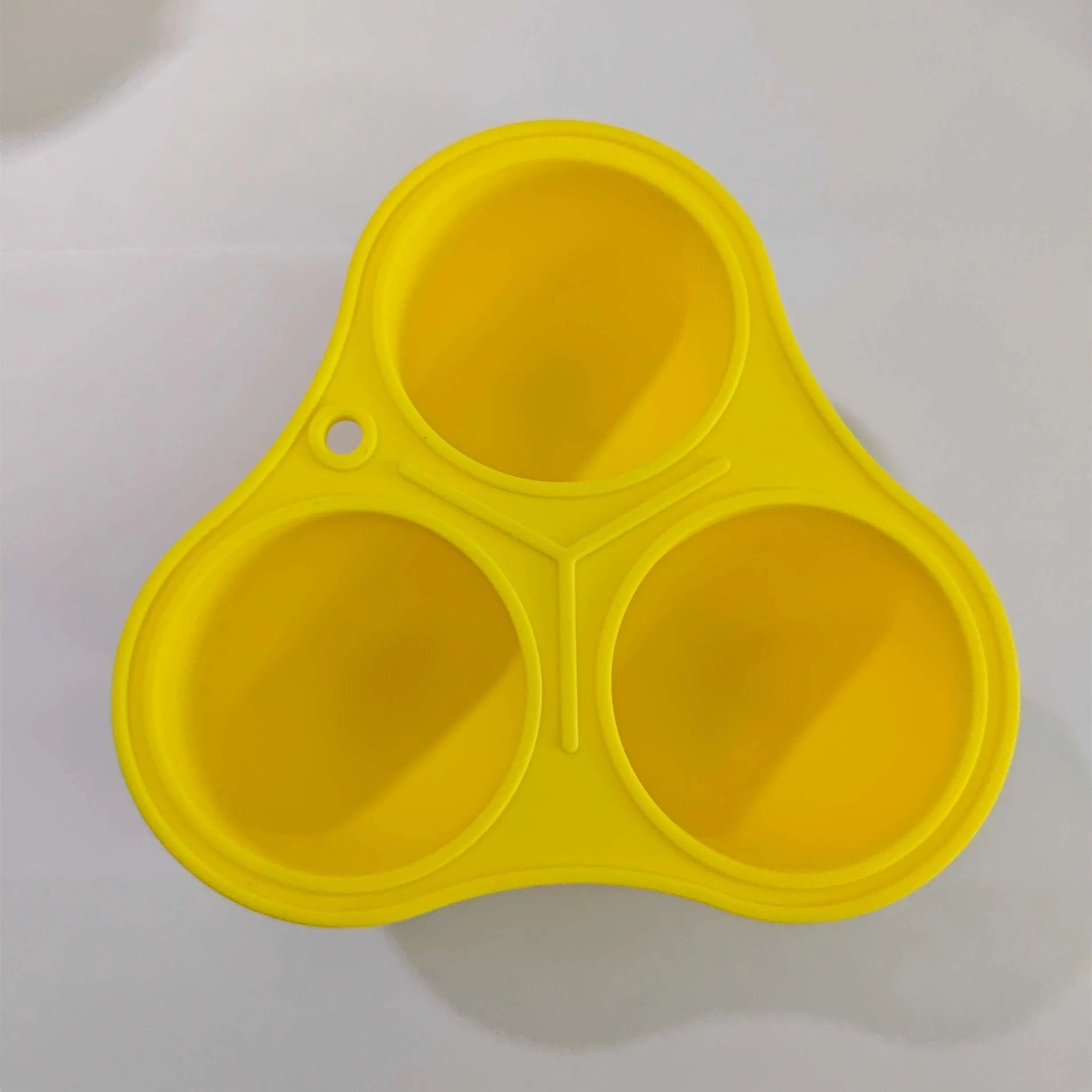 Yellow silicone pet slow feeder ball with snack mould for dogs and cats