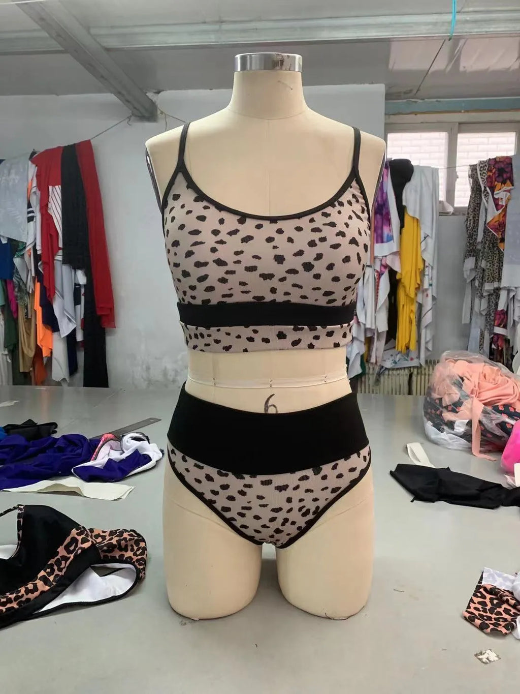 White and leopard print women's high waist split leg bikini swimsuit briefs on a mannequin.