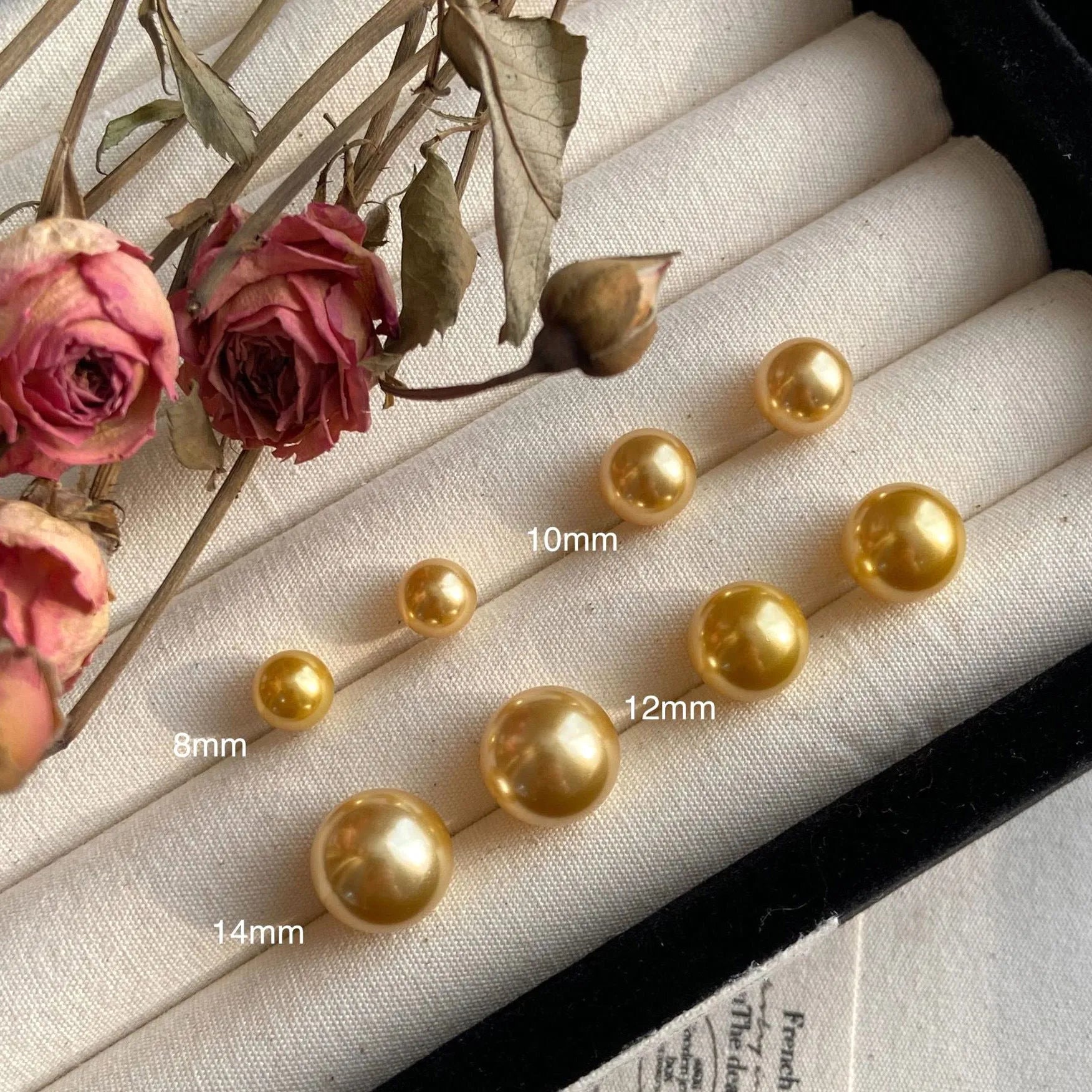 A pair of large pearl stud earrings with a geometric silver setting and an eight-point star detail.