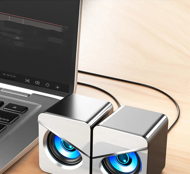 Black USB wired mini desktop speaker with volume knob next to white version, both measuring 7.5cm wide
