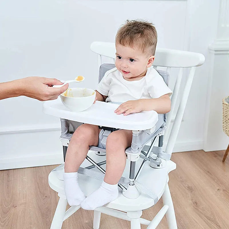 Foldable baby dining chair with safety belt, removable tray, and storage bag in pink