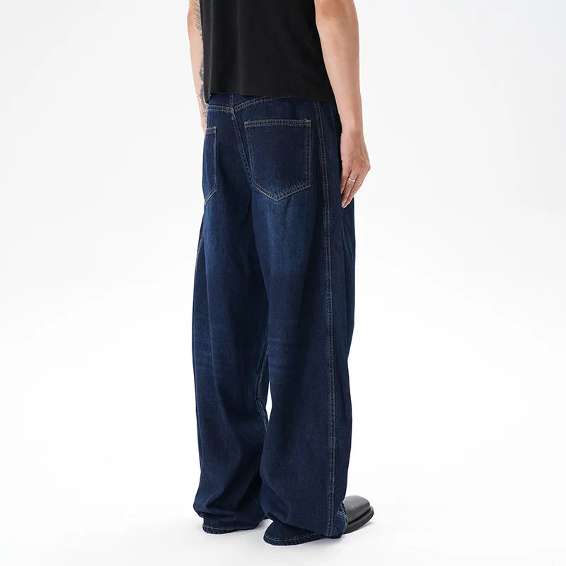 Dark blue washed distressed wide leg machete jeans on a model, showing the denim fabric and relaxed fit.