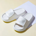 Pair of thick-soled EVA flip-flop slippers in a choice of seven colours, shown on a wet bathroom floor.