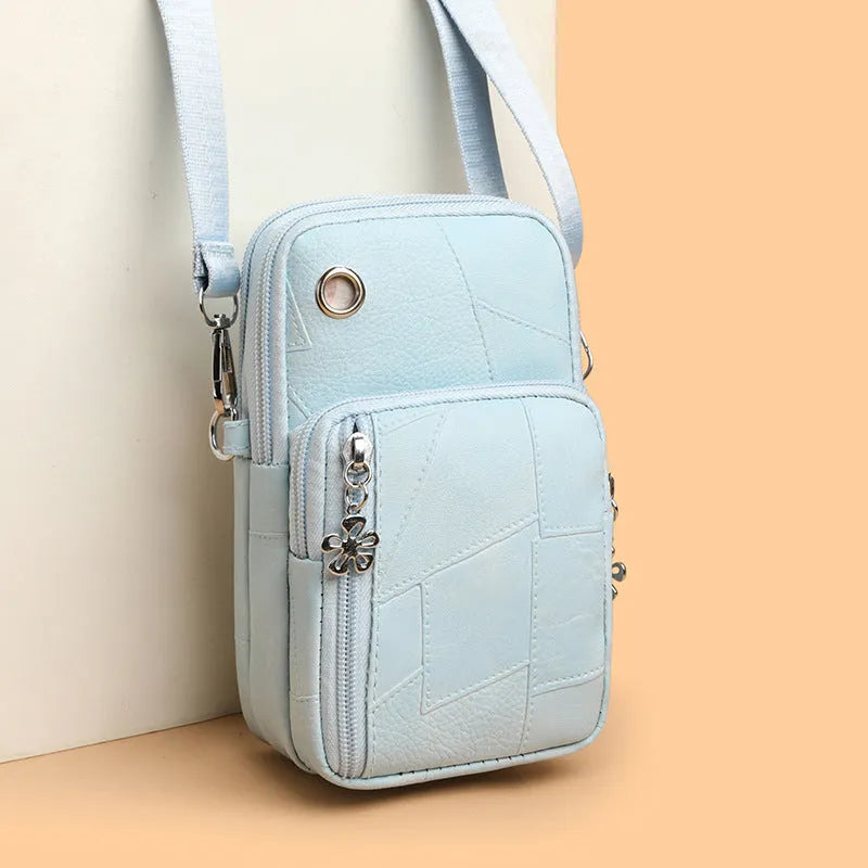 Square vertical mini mobile phone bag in PU leather, shown in water blue colour with a front sandwich pocket.