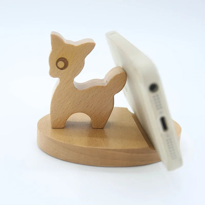 Beech wood and resin lazy bracket mobile phone holder in an animal design style on a desk.