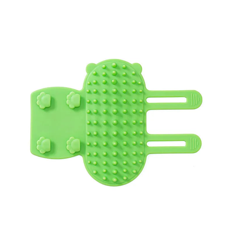 Black silicone cat grooming brush with comb teeth and an adjustable mounting strap.