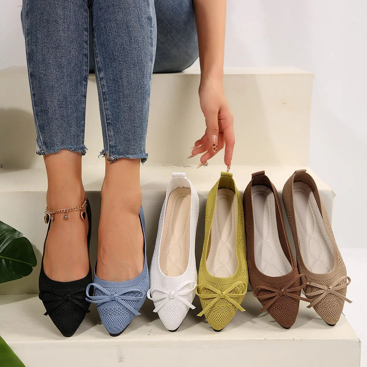 Women's blue knitted loafers with a bow and pointed toe on a flat rubber sole.