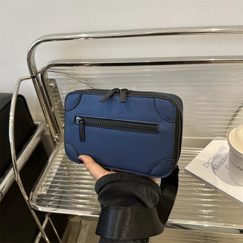 Women's black square crossbody bag showing internal mobile phone pocket and adjustable shoulder strap