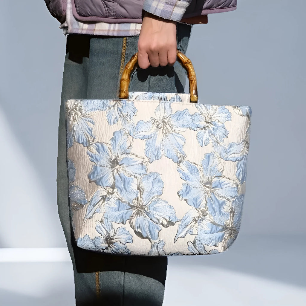 Women's light blue canvas shoulder bag with bronzing flower detail showing horizontal square shape and double straps