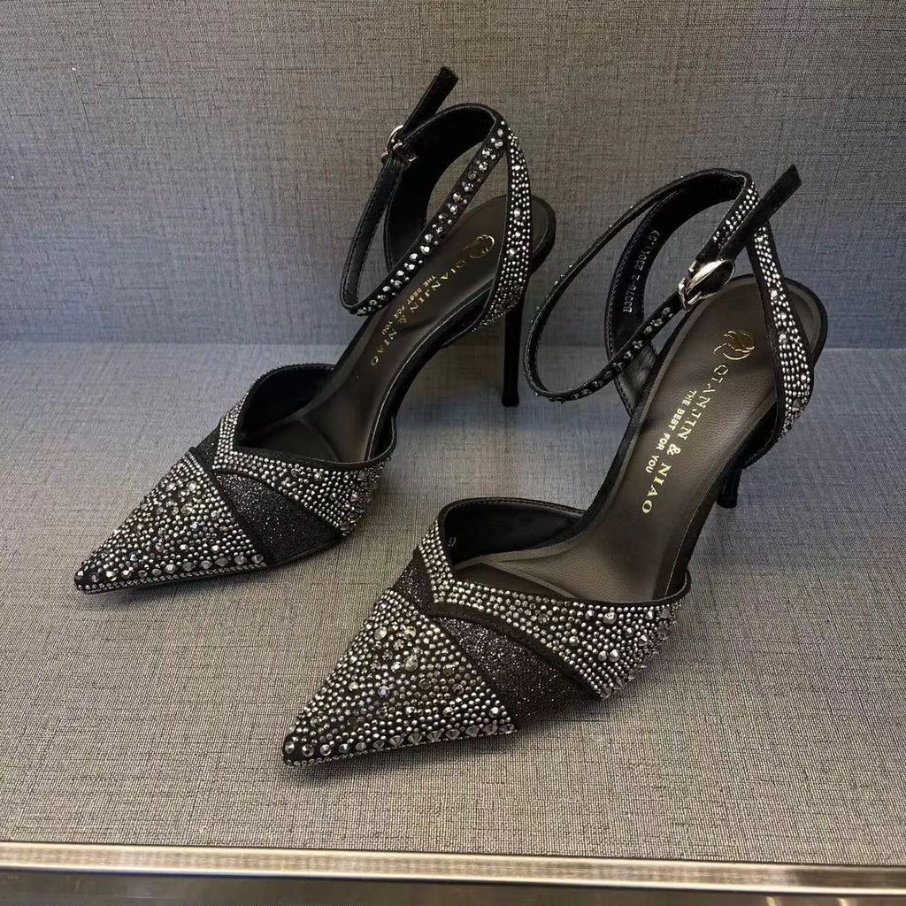 Black women's stiletto high heel shoe with a pointed toe and a bright red sole.