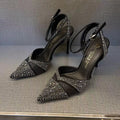 Black women's stiletto high heel shoe with a pointed toe and a bright red sole.