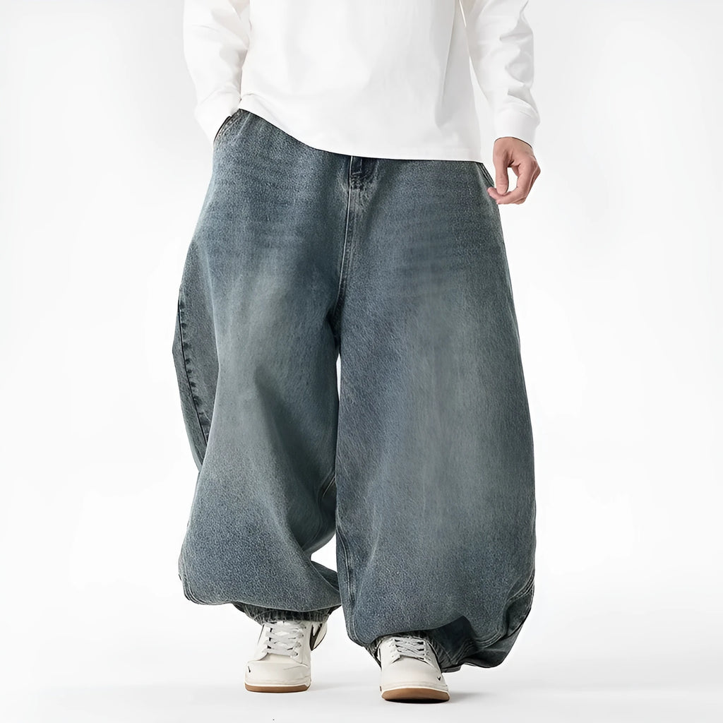Men's plus-size light blue wide-leg baggy denim jeans on a hanger.
