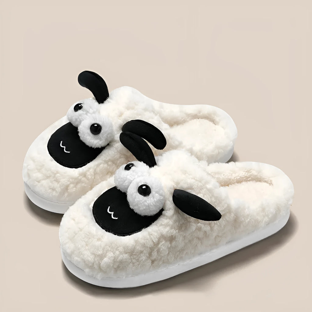 Brown suede slip-on slippers with a sewn PVC sole on a wooden floor.