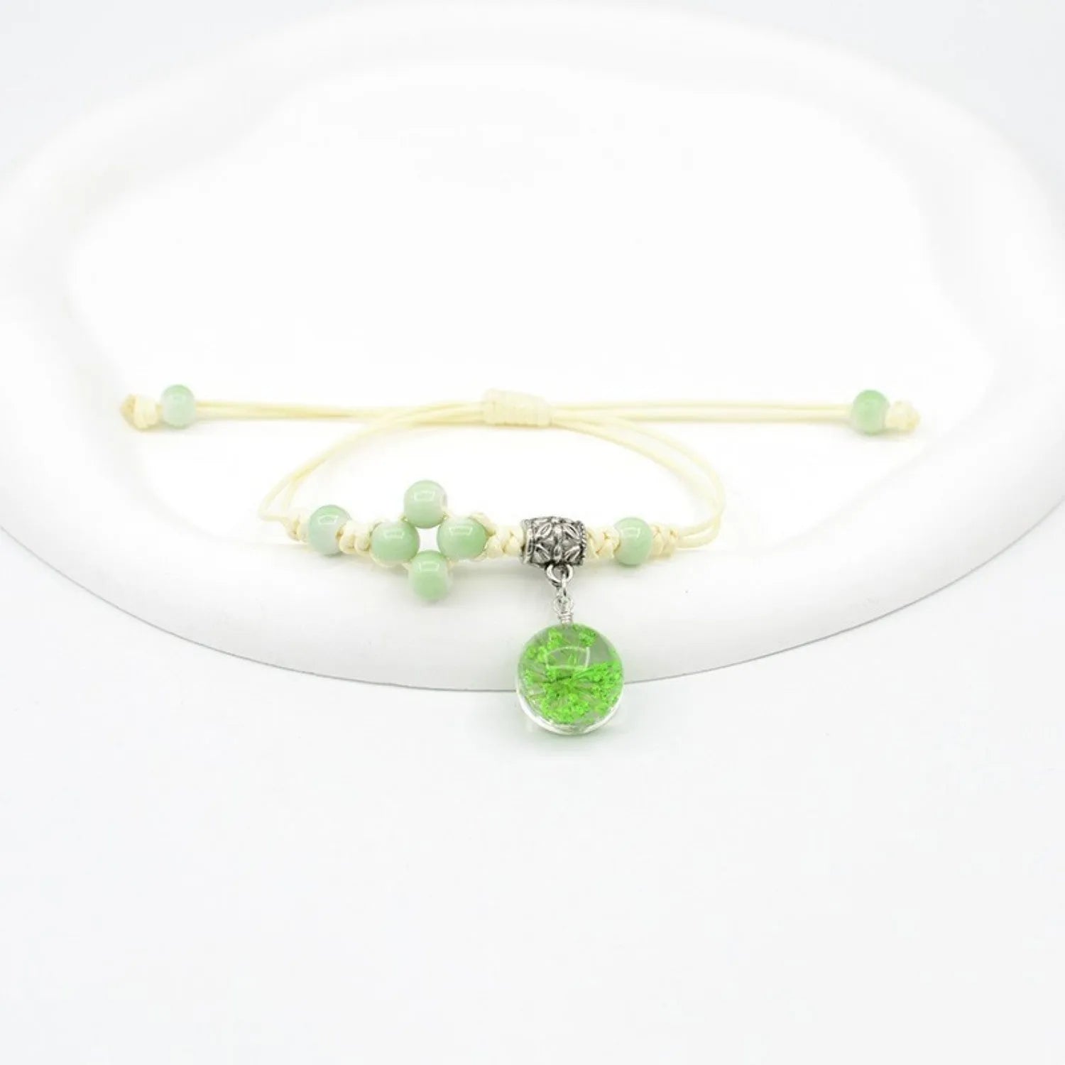 Close-up of a hand-woven glass bracelet with large 1.4cm beads containing real dried flowers in various colours.