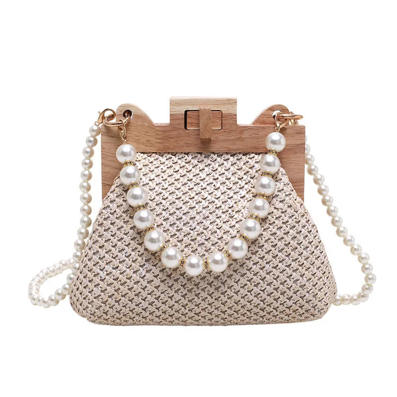 Women's straw woven shoulder bag with pearl chain strap showing interior organisation pockets