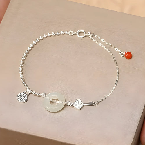Women's silver bracelet with a geometric Hetian jade Wishful Blessings charm on a white background.