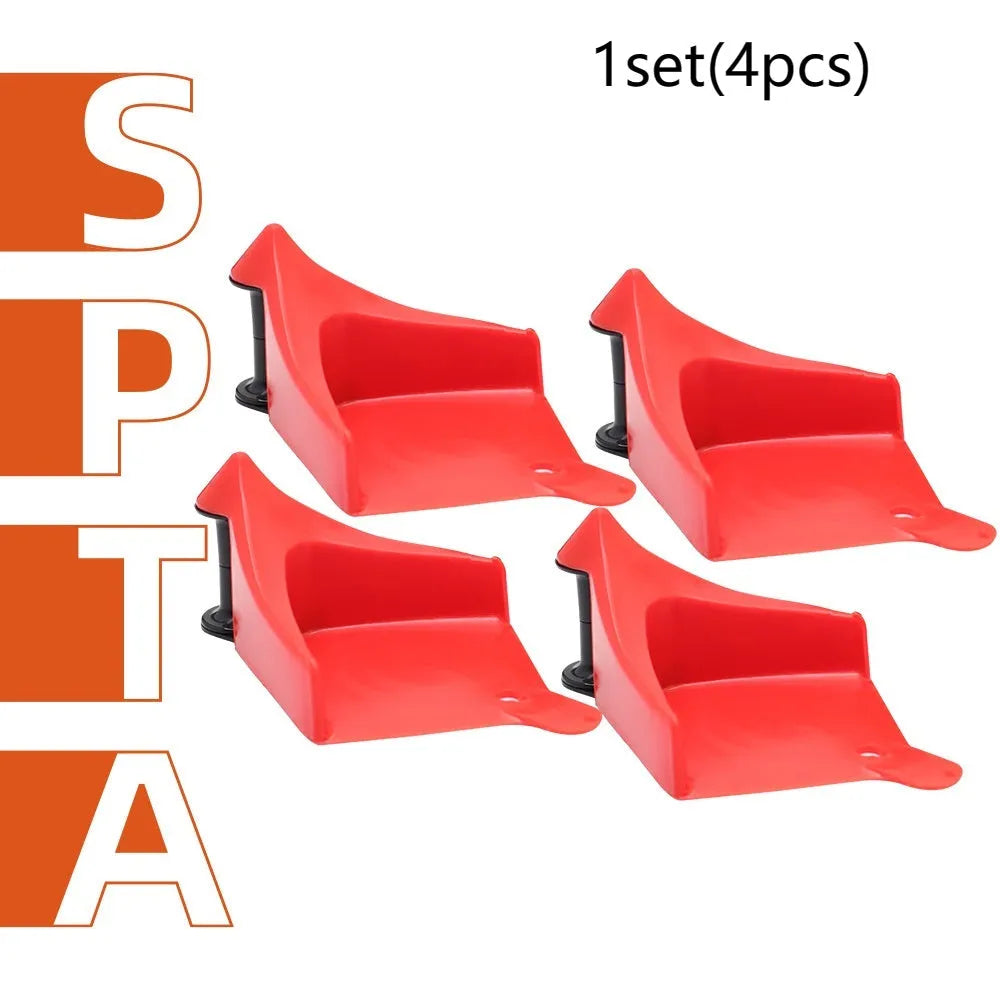 Set of four bright red triangular plastic parking wheel chocks on a grey background