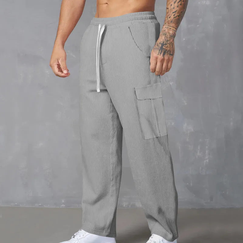 Men's loose-fitting corduroy cargo trousers in a straight-leg cut, shown in a solid colour.