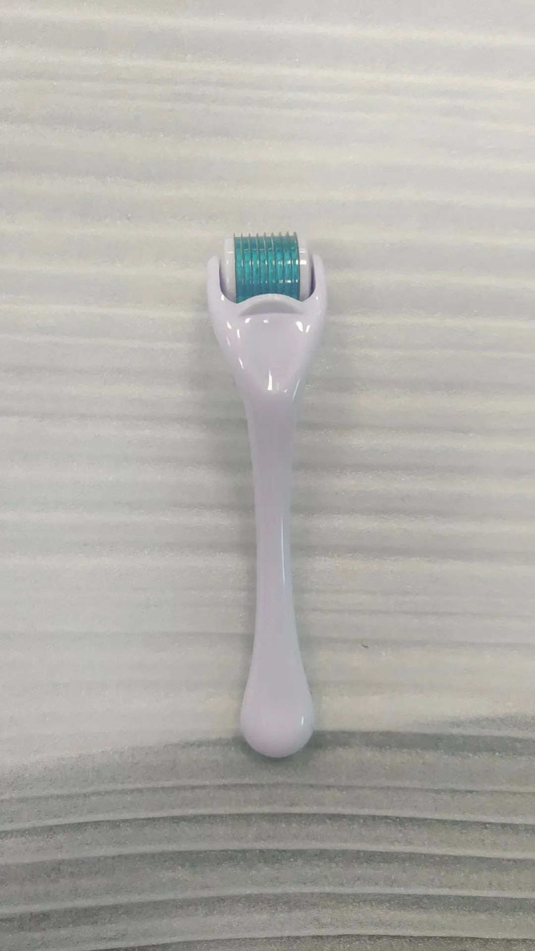 540 micro needle derma roller with black handle and purple wheel, showing adjustable needle sizes.