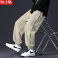Men's loose fit cotton pants with elasticated ankle bands in grey green colour, showing collage stitching detail.