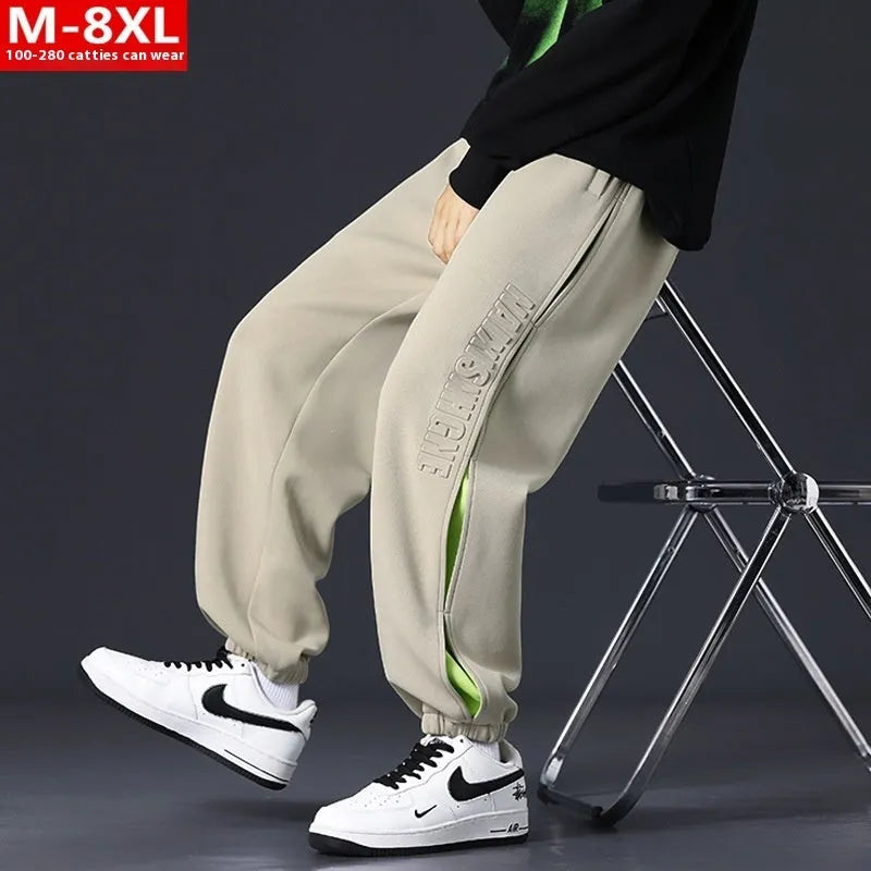 Men's loose fit cotton pants with elasticated ankle bands in grey green colour, showing collage stitching detail.