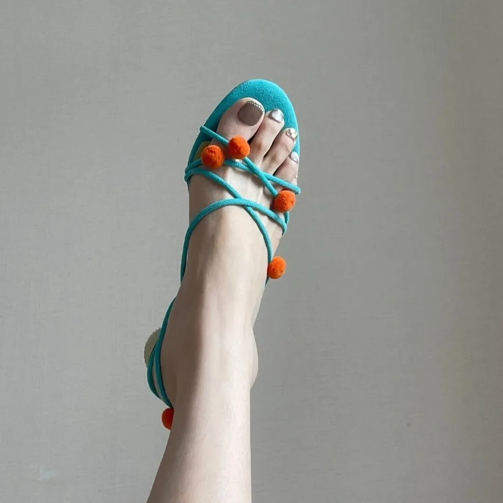 Cyan women's high-heeled sandals with lace-up ball detail and thin straps, open toe, on a rubber sole.