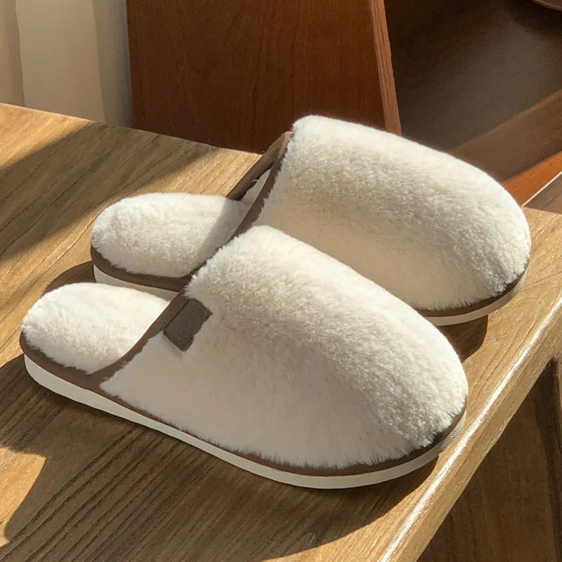 Solid colour winter plush slippers with non-slip PVC soles on a wooden floor