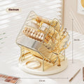 Rotating clear plastic cosmetics storage box with tiered compartments for brushes and bottles.