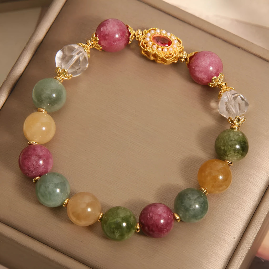 Close-up of a women's bracelet with multicolour tourmaline beads on an alloy band with crystal and rhinestone details.