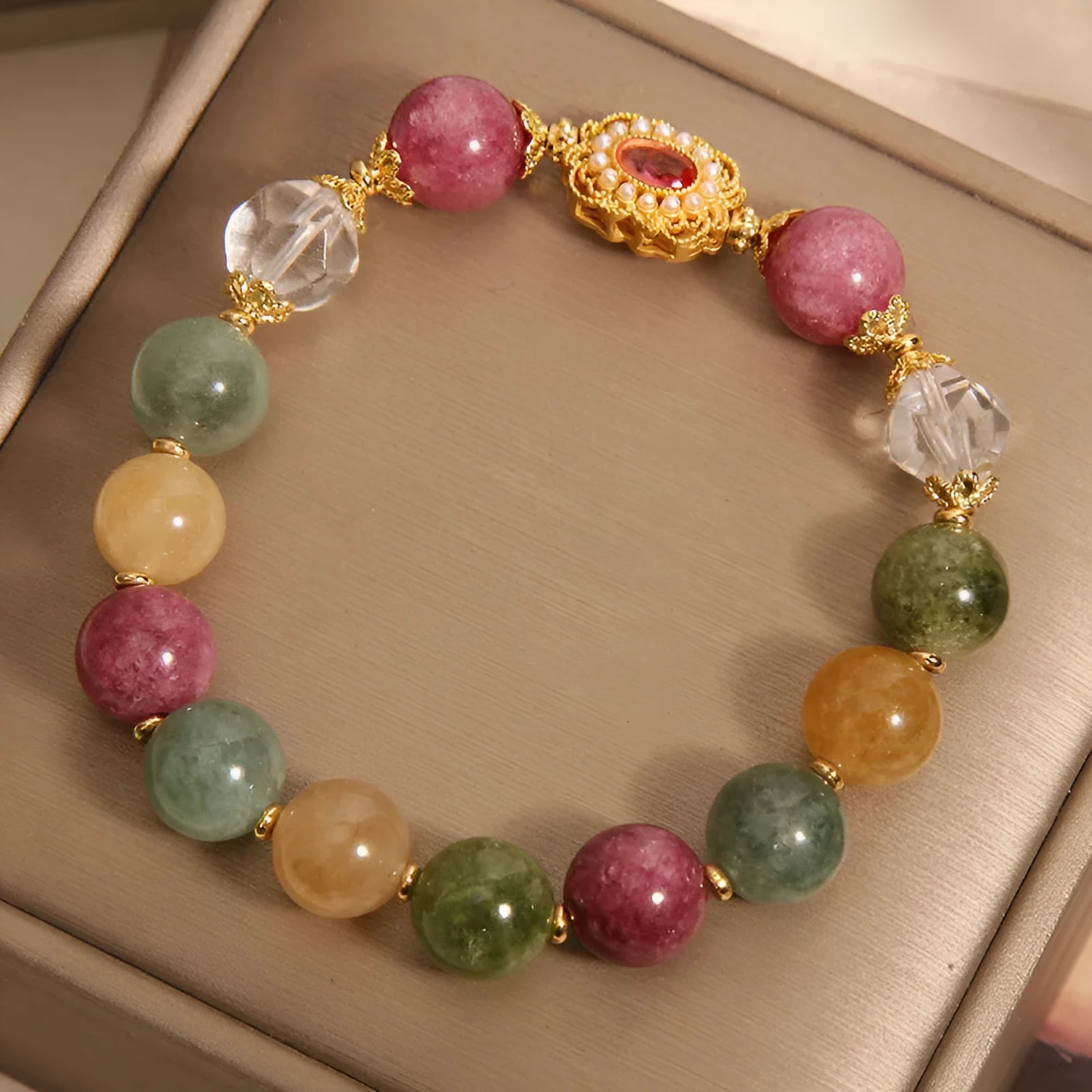 Close-up of a women's bracelet with multicolour tourmaline beads on an alloy band with crystal and rhinestone details.