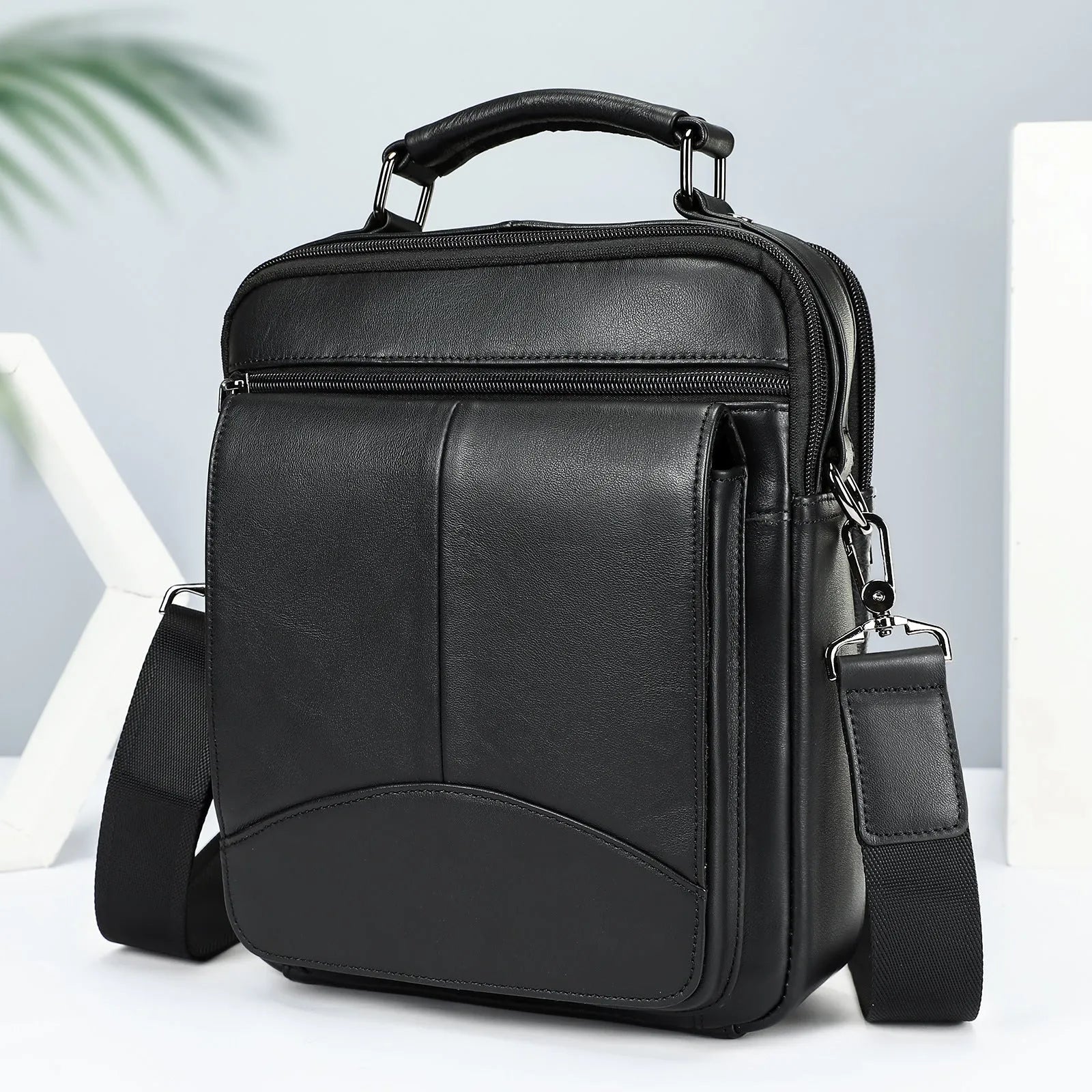 Men's genuine leather messenger bag in black with visible sewing line details and shoulder strap