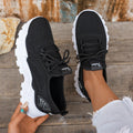 Women's white Flyknit mesh casual sports shoes with flat heel and lace-up front.